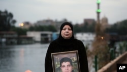 Amel Shaker holds a portrait of her 25-year-old son Ahmed, who was fatally shot in the back on the “Friday of Rage,” one of the bloodiest days of Egypt's 2011 uprising against longtime autocrat Hosni Mubarak, in Cairo, Egypt.