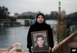 Emel Şakir, 2011 yılındaki gösterilerde öldürülen 25 yaşındaki oğlunun portresiyle