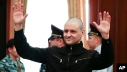 FILE - Russian opposition activist Sergei Udaltsov waves in a court room prior to a hearing in the Bolotnaya Square protest trial in Moscow, July 24, 2014. Udaltsov said, Aug. 10, 2017, that he is encouraging activists to boycott next year's elections.