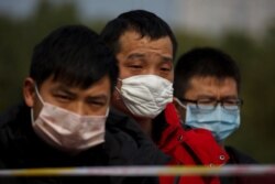 People coming from the Hubei province wait at a checkpoint at the Jiujiang Yangtze River Bridge in Jiujiang, Jiangxi province, China, as the country is hit by an outbreak of a new coronavirus, February 1, 2020.