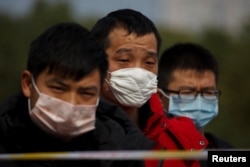 People coming from the Hubei province wait at a checkpoint at the Jiujiang Yangtze River Bridge in Jiujiang, Jiangxi province, China, as the country is hit by an outbreak of a new coronavirus, February 1, 2020.