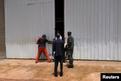 Soldiers pull open the doors to a warehouse inside former Gambian President Yahya Jammeh's personal estate in Kanilai, Gambia, July 1, 2017.