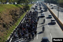 Salvadorans take part in a new caravan of migrants, heading to the United States, as they leave San Salvador, El Salvador, Jan. 16, 2019.