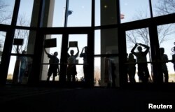 FILE - People who could not get into the event because of space limits hold signs outside a town hall meetingin North Charleston, South Carolina, Feb. 25, 2017.