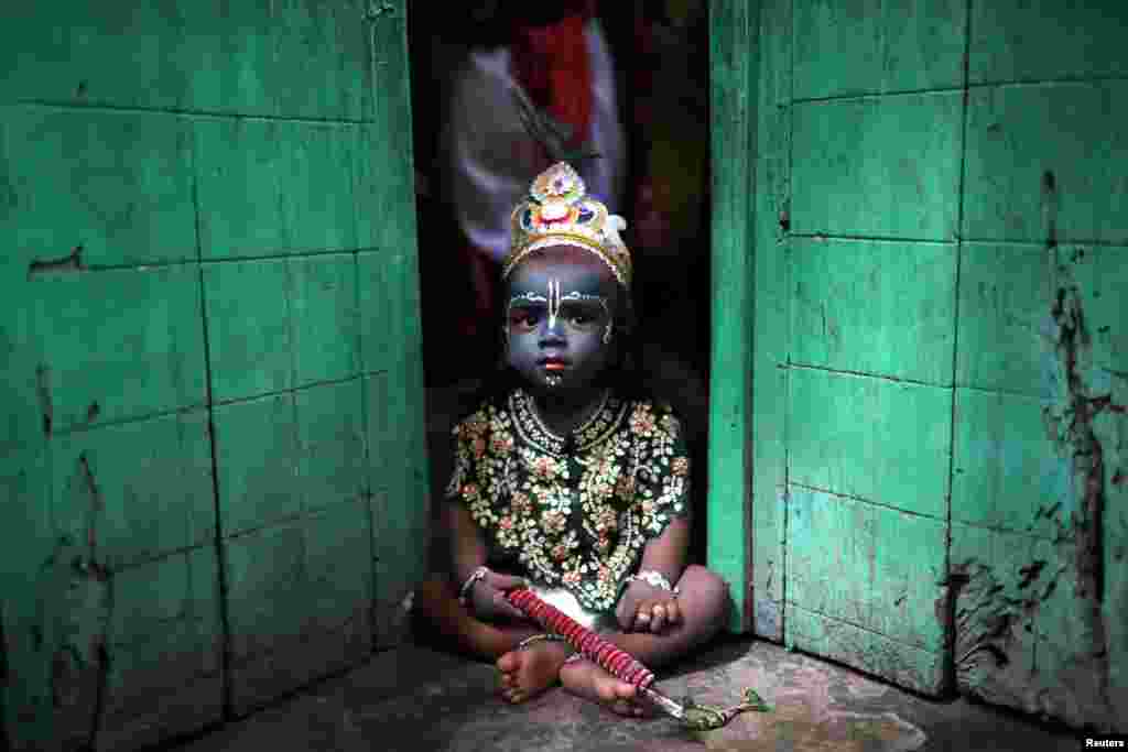 A child dressed as Lord Krishna during Janmashtami festival, sits on a doorstep in Dhaka, Bangladesh. The festival&nbsp; marks the birth anniversary of Lord Krishna.