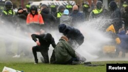 Demonstran yang menentang pembatasan sosial terkait COVID-19 bentrok dengan polisi dalam aksi di Amsterdam, Belanda (foto: dok). 