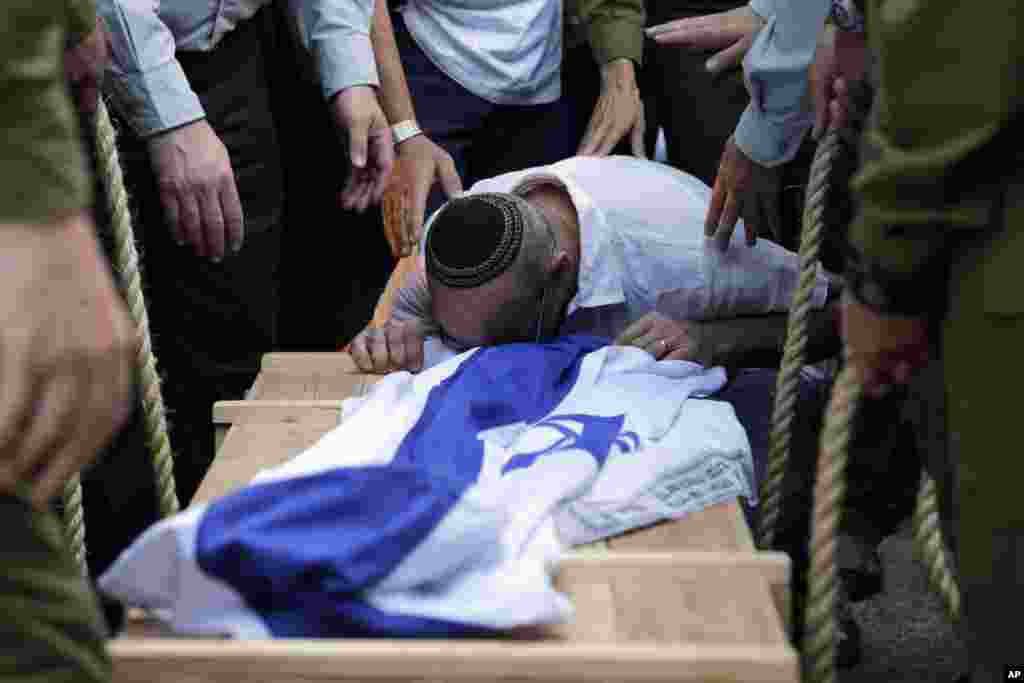 A relative of Israeli soldier Jordan Ben-Simon, who also held French citizenship and was killed in fighting in Gaza, mourns over his coffin during his funeral in Ashkelon, Israel, July 22, 2014.