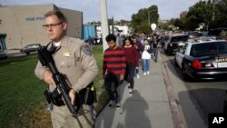 Srednjoškolci uz policijsku pratnju napuštaju Sogus srednju školu u Santa Klariti, u Kalifroniji, posle izveštaja o pucnjavi (Foto: AP/Marcio Jose Sanchez) 