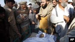 Dân làng đứng cạnh thi hài nhân viên y tế Hilal Khan, bị giết 