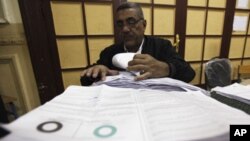 An official examines votes from ballot boxes after the polls closed in Cairo, March 19, 2011