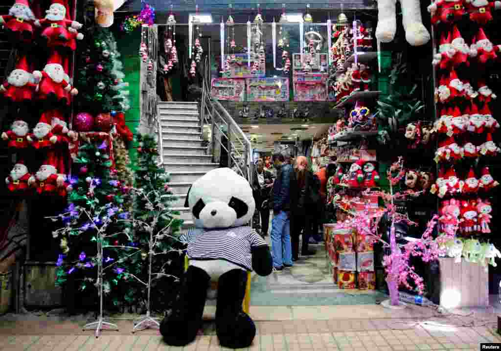 Egyptians look at Santa Claus toys in a shop as the capital is on high security alert on the Christmas eve in Cairo, Dec. 24, 2017.