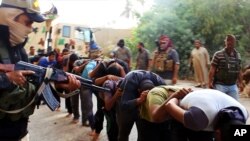 지난 6월 이슬람 수니파 무장반군 '이슬람국가'가 생포한 이라크 정부군 병사들을 향해 총을 겨누고 있다.