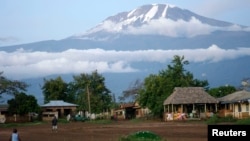 FILE - Houses sit near the foot of Mount Kilimanjaro, one of the country's top tourist draws, in Tanzania's Hie district.