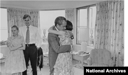 Richard Nixon hugs daughter Julie Nixon Eisenhower shortly after resigning from office on August 9, 1974. Also pictured are Nixon's daughter Tricia Cox and her husband, Ed Cox. (National Archives)
