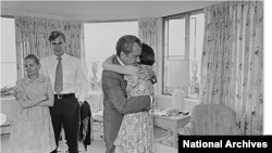 FILE - Richard Nixon hugs daughter Julie Nixon Eisenhower shortly after resigning from office on August 9, 1974. Also pictured are Nixon’s daughter Tricia Cox and her husband, Ed Cox. (National Archives)