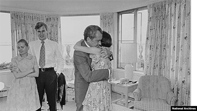 FILE - Richard Nixon hugs daughter Julie Nixon Eisenhower shortly after resigning from office on August 9, 1974. Also pictured are Nixon’s daughter Tricia Cox and her husband, Ed Cox. (National Archives)