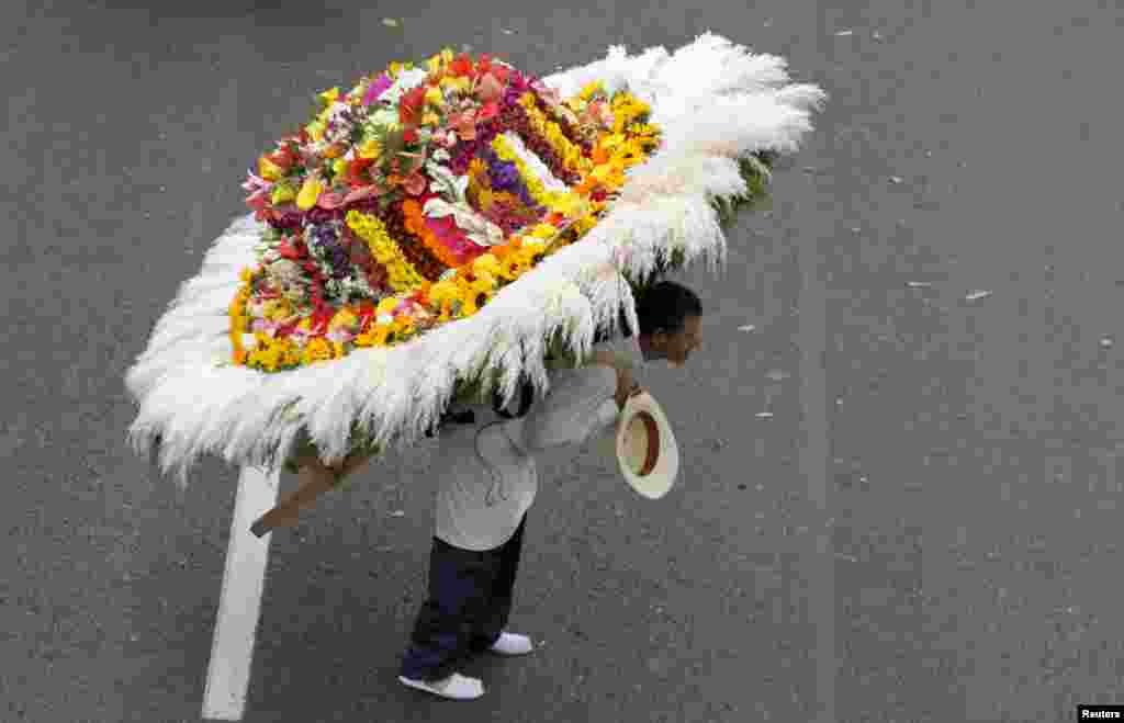 Seorang pria mengenakan rangkaian bunga di pundaknya ikut dalam parade bunga tahunan, di mana para petani bungan yang dikenal dengan &quot;silleteros&quot; menampilkan rangkaian bunga mereka, di Medellin, Colombia, 9 Agustus 2015.