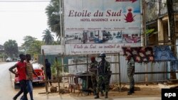 Des soldats ivoiriens patrouillent à l'extérieur de l'Etoile du Sud hôtel à côté de quelques passants à Grand Bassam, Côte-d'Ivoire, 14 mars 2016. epa/ LEGNAN KOULA