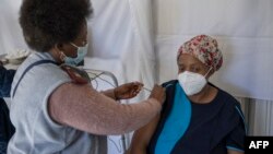 Un agent de santé administre un vaccin contenant le vaccin Pfizer sur un soignant de la maison de retraite SAVF Evanna Tehuis près de Klerksdorp, le 19 mai 2021.