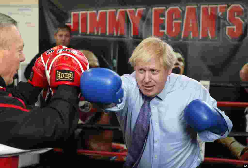 Britain&#39;s Prime Minister Boris Johnson works out with trainer Steve Egan during a stop in his General Election Campaign trail at Jimmy Egan&#39;s Boxing Academy in Manchester, England.