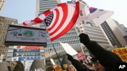 Para demonstran di Seoul melambai-lambaikan bendera AS dan Korea Selatan dalam aksi yang mendukung sistem pertahanan misil AS, THAAD (15/2). (AP/Ahn Young-joon)