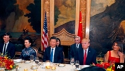 El presidente Donald Trump y el presidente chino Xi Jinping, con sus esposas, la primera dama Melania Trump y la primera dama china Peng Liyuan, están sentados durante una cena en Mar-a-Lago el jueves 6 de abril de 2017 en Palm Beach.