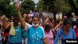 Parientes de los prisioneros de la cárcel Los Llanos, en Guanare, Venezuela, rezan por sus familiares que se encuentran en el centro penitenciario en donde el viernes 1 de mayo murieron 47 personas.