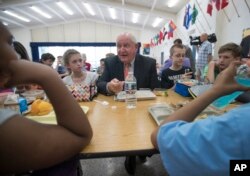 FILE - Agriculture Secretary Sonny Perdue eats lunch with students at the Catoctin Elementary School in Leesburg, Virginia, May 1, 2017.