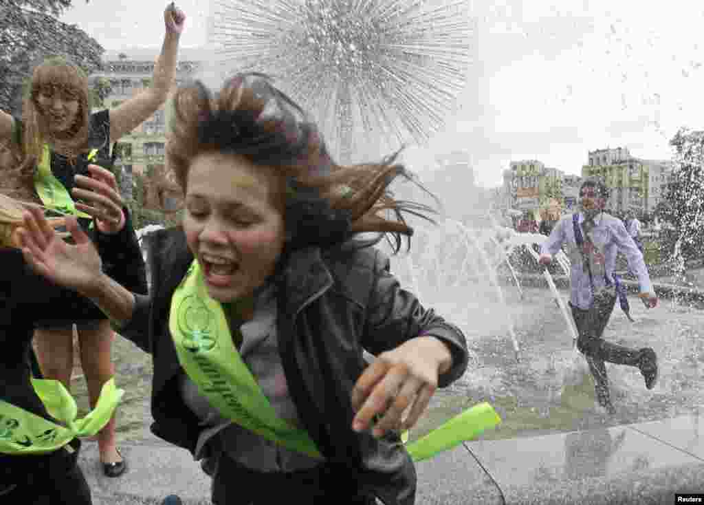 Secondary school graduates play in a fountain as they celebrate the last day of school in Kyiv, Ukraine. 