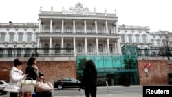 People pass by Palais Coburg hotel where nuclear talks are taking place in Vienna, Feb. 19, 2014. 