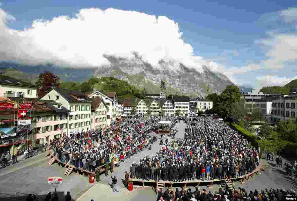 People hold up their voting cards during the annual Landsgemeinde meeting at the Zaunplatz square, in the eastern Swiss town of Glarus. Glarus is one of Switzerland&#39;s two remaining Landsgemeinden, a 700-year tradition of an open-air assembly in which citizens can make key political decisions directly by raising their hands.