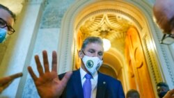 Sen. Joe Manchin, D-W.Va., speaks to a reporter during the vote on a temporary government funding bill to avert a shutdown, at the Capitol in Washington, Sept. 30, 2021.