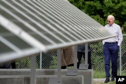 Former vice president and Democratic presidential candidate Joe Biden looks at an array of solar panels during a tour at the Plymouth Area Renewable Energy Initiative, June 4, 2019, in Plymouth, N.H.