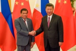 FILE - Chinese President Xi Jinping, right, shakes hands with Philippines President Rodrigo Duterte before their bilateral meeting during the Belt and Road Forum, Beijing, May 15, 2017.