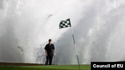 Ombak tinggi pecah di belakang pemain golf Todd Linehan dalam pertandingan Pebble Beach Golf Links Pantai Pebble, California (10/12), akibat badai kuat. (Reuters/Michael Fiala)