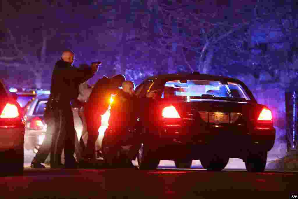 Police with guns drawn search for a suspect on April 19, 2013 in Watertown, Massachusetts.