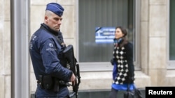 FILE - A Belgian police officer secures the area around the European Council headquarters.