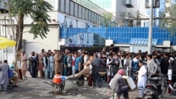 Afghans wait in long lines for hours to try to withdraw money, in front of Bank in Kabul, Afghanistan, Monday, Aug. 30, 2021. The Taliban have limited weekly withdrawals to $200. (AP Photo/Khwaja Tawfiq Sediqi)