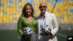 Brazilian singer Claudia Leitte and rapper Pitbull pose at the Maracana stadium in Rio de Janeiro, Brazil, Jan. 23, 2014. 