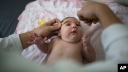 FILE - A baby's head is measured by a neurologist at the Mestre Vitalino Hospital in Caruaru, Pernambuco state, Brazil, Dec. 22, 2015.