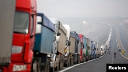 FILE - Trucks are seen on a highway near the Kulata border crossing between Bulgaria and Greece, Bulgaria, Feb. 17, 2016. Truck drivers blocked roads across Bulgaria on Thursday, protesting proposed EU transport rules.