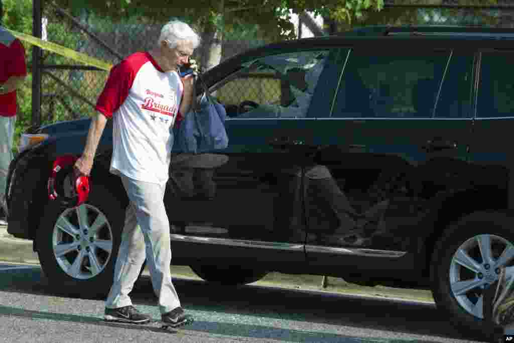 Rep. Jack Bergman, R-Mich. talks on the phone while walking past a damaged vehicle at a shooting scene where House Majority Whip Steve Scalise was shot at a Congressional baseball practice, June 14, 2017, in Alexandria.