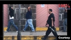 En una imagen del clausurado noticiero nicaragüense 100% Noticias, aparece el ahora sancionado comisionado policial, Ramón Avellán, custodiando con una pistola en la mano a varios manifestantes arrestados en 2018. Foto cortesía 100% Noticias.