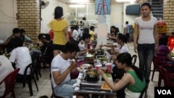Transgender waitresses walk past customers dining on seafood hotpot at Thuy Linh, a restaurant famous for embracing the LGBT crowd, in Ho Chi Minh City, Vietnam, Apr. 2, 2013.