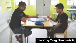 Scrabble player Tengku Ariff Shah (R) and his coach Ganesh Asirvatham practice before the WESPA Youth Cup 2019 in Kuala Lumpur, Malaysia, November 30, 2019. (Reuters/Lim Huey Teng)