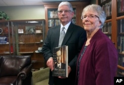 Arthur Young, left, and his wife, Pat, hold one of the 2,744 books about U.S. presidents he donated to the New Hampshire Political Library, part of the New Hampshire Institute of Politics at Saint Anselm College in Manchester, New Hampshire, June 9, 2017.