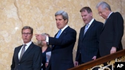 U.S. Secretary of State John Kerry, gestures in centre, with German Foreign Minister Guido Westerwelle, left Canadian Foreign Minister John Baird and Italian PM Mario Monti as theywalk down the stairs for a press conference on sexual violence against women during a G8 Foreign Ministers in London, April, 11, 2013.