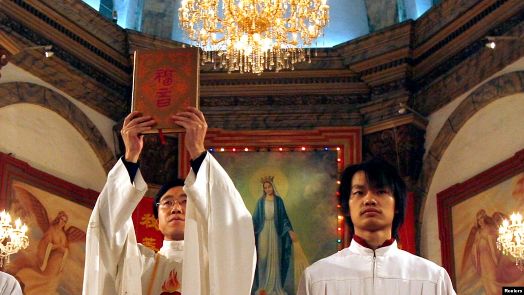 资料照： 北京天主教堂里的一名神职人员在做圣诞弥撒时高举中文版的圣经。（2007年12月24日）(photo:VOA)