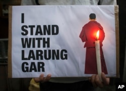 An exiled Tibetan holds a placard as he participates in a protest against the demolition of buildings in Larung Gar by Chinese authorities, during a demonstration in Dharmsala, India, Aug. 10, 2016.