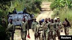 Des soldats des forces armées de la République démocratique du Congo (FARDC) patrouillent le village abandonné de Kaswara, à 60 km au sud-ouest de Bunia, dans la région de l'Ituri, dans l'est de la République démocratique du Congo, le 14 juillet 2006.